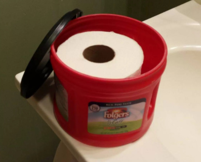 plastic Folgers coffee canister filled with toilet paper roll