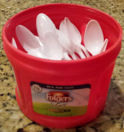 plastic Folgers coffee can filled with plastic spoons