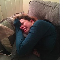 Photo of a woman on the couch criyng