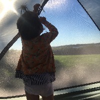 girl looking out of tent window