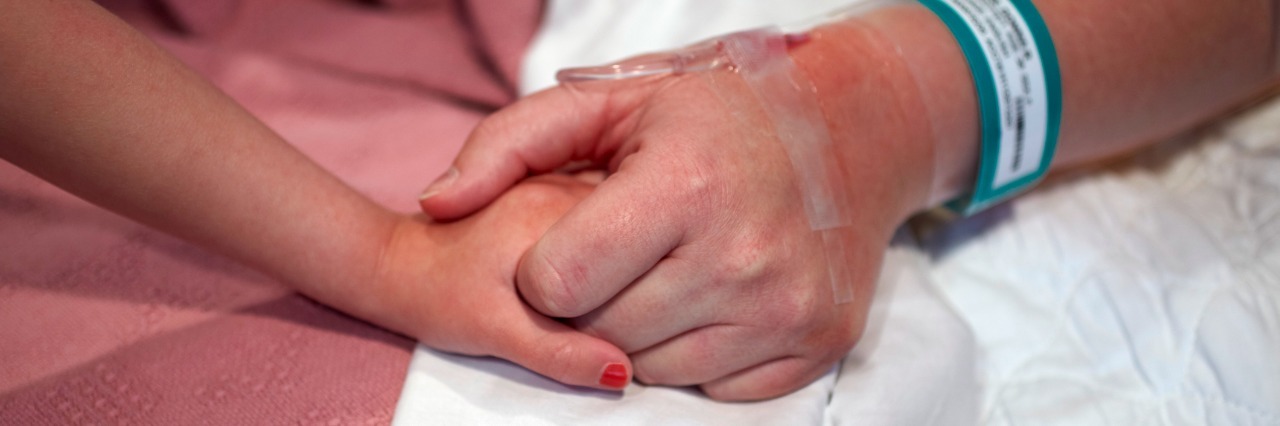 When My Daughter Called Me 'Brave' in the ER Female hospital patient holding a preschool age girl's hand.