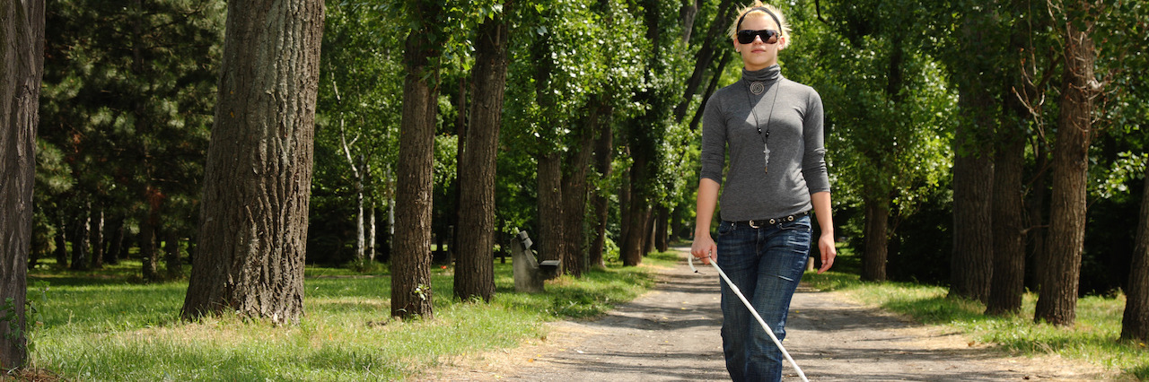 Tips for Interacting With Blind People Blind woman walking in a park.