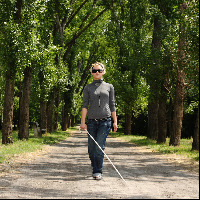 Blind woman walking in a park.