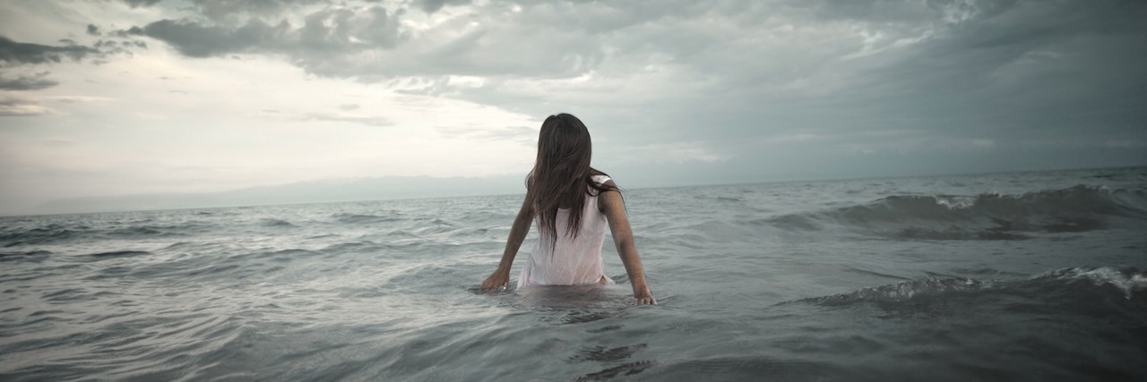 A woman standing in a stormy ocean