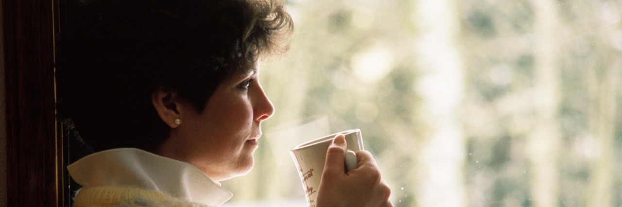 woman drinking tea by window
