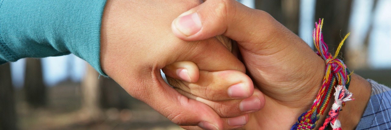 Close-up of two people holding hands outdoors
