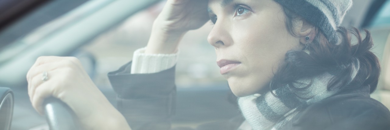The 'Worry Stones' I Carry With Each Brain Surgery Mid adult looking away with sad expression while driving her car