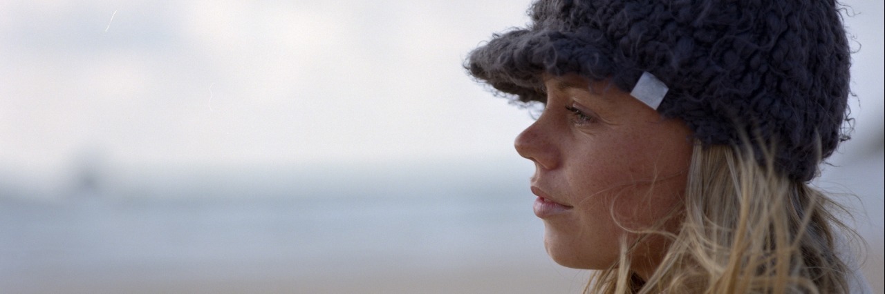 To the Person Who Doesn't Know How to Help Me With Anxiety Young woman wearing hat, standing on beach, profile