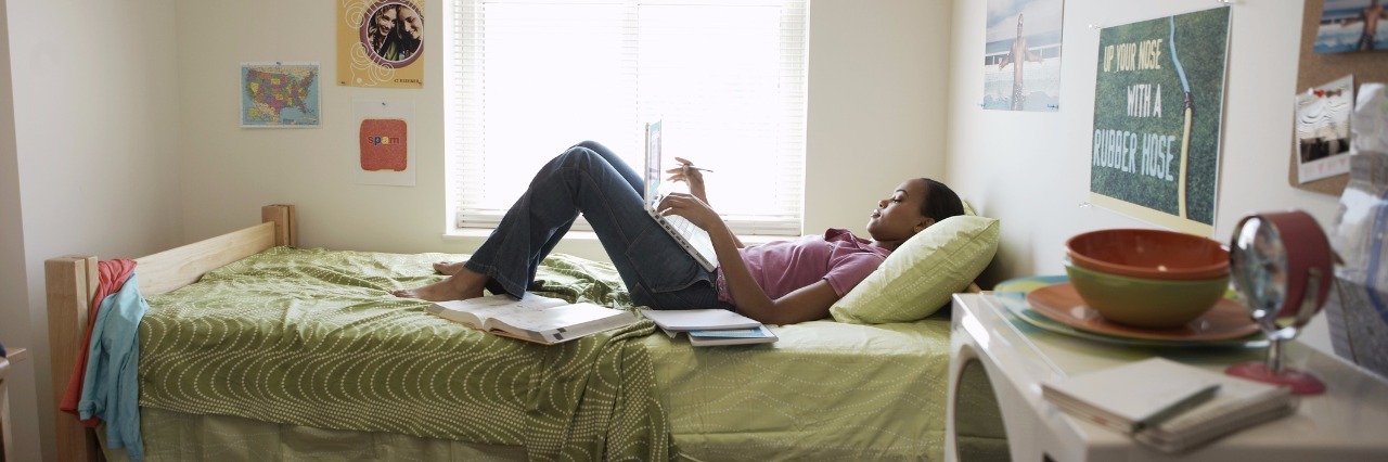 Why It's OK to Have a Messy House With Chronic Back Pain woman lying on bed in messy room