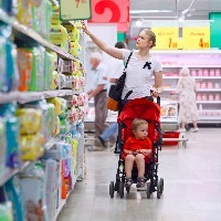 Mother with her boy in baby carriage in the supermarket