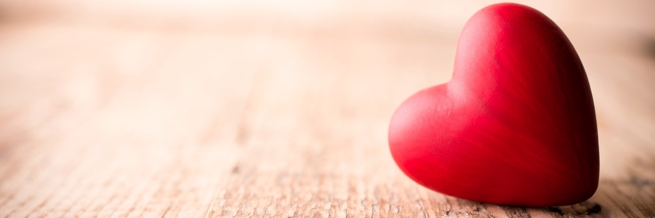 Eating Disorder Recovery on Valentine's Day Red heart-shaped candy on a wooden background.