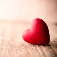 Red heart-shaped candy on a wooden background.