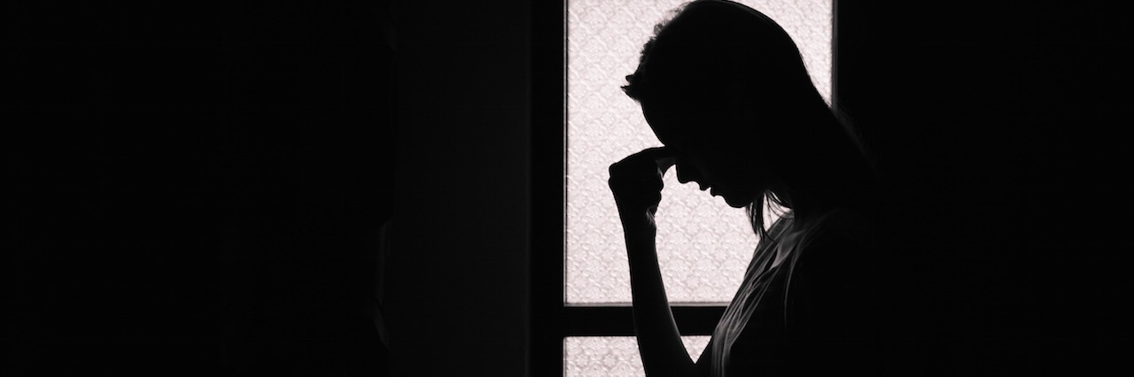 What Negative Thoughts in Depression Really Sounds Like Depressed young woman in a dark room