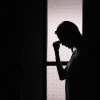 Depressed young woman in a dark room