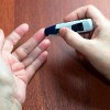 woman testing her finger for diabetes