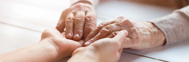 Up close photo of a senior woman's hands being held