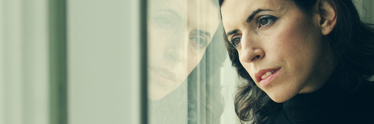 The Moment I Realized I Would Never 'Get Better' From Genetic Mutation woman stands in front of the window