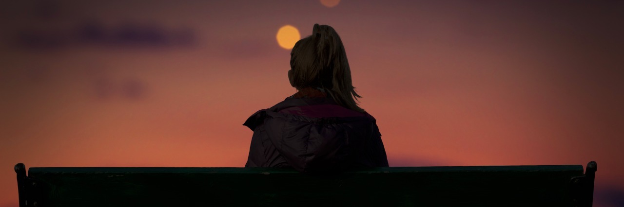 silhouette of a girl watching defocused city lights