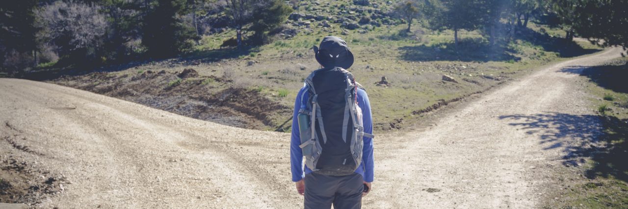 Choosing to Lose My Choices to Stuttering Man standing at a fork in the road.