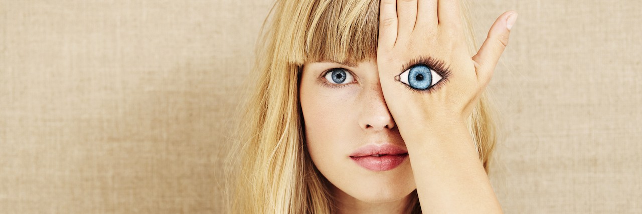 A Description of Anxiety Using Senses A woman holding her hand over her eye