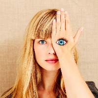 A woman holding her hand over her eye