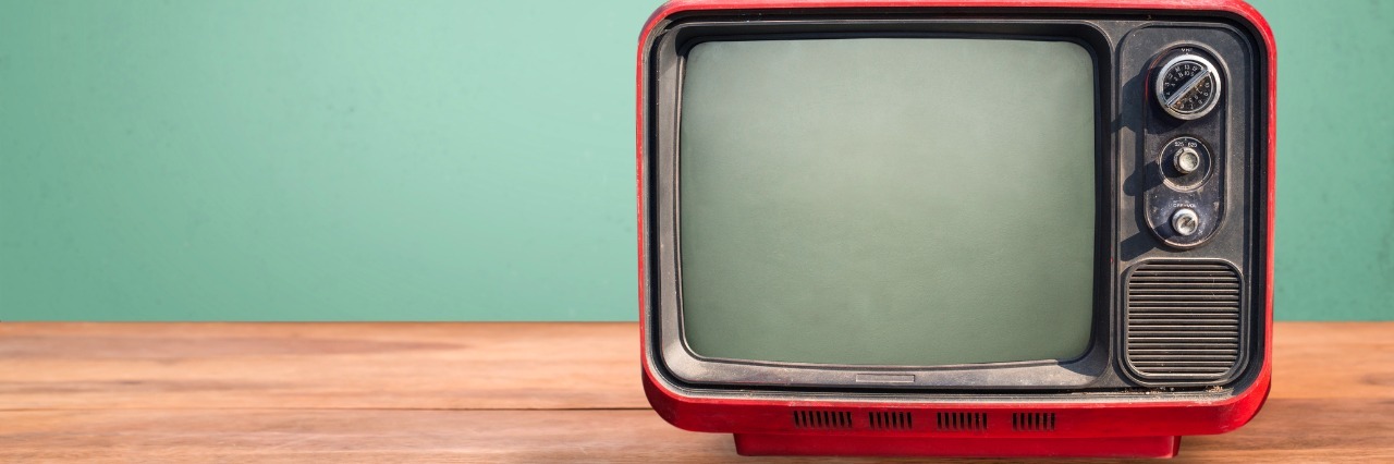 It's Important to Represent Mental Illness Positively on Television Retro red television on wood table with vintage aquamarine wall background