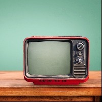 Retro red television on wood table with vintage aquamarine wall background