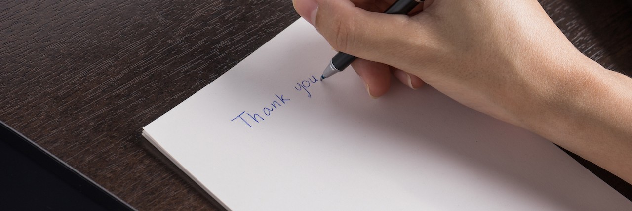 A woman writing a thank you letter