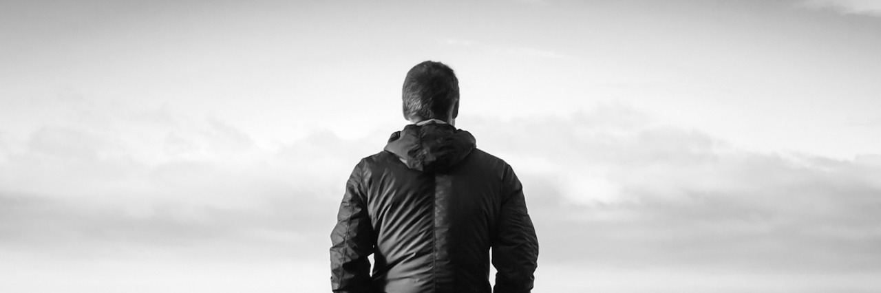 Black and white photo of man in front of gray sky