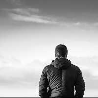Black and white photo of man in front of gray sky