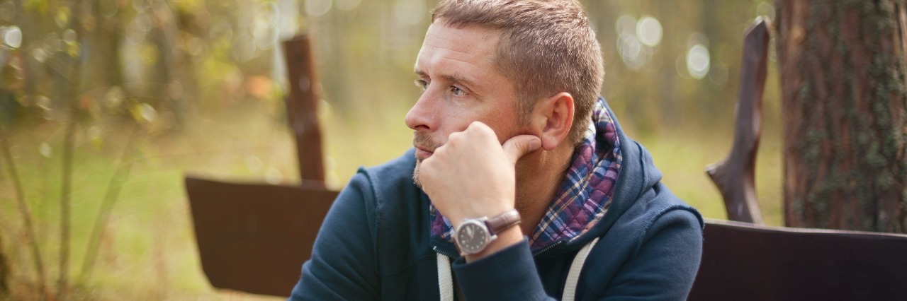 man sitting on a park bench and thinking