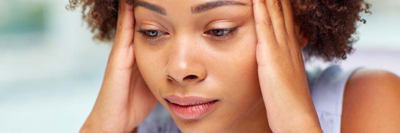 How I Win the Raging War of Chronic Pain woman touching sides of her head in pain