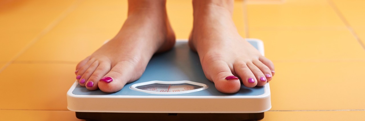 Eating Disorder Recovery: How I'm Learning Who I Am Beyond the Scale Pair of female feet on a bathroom scale