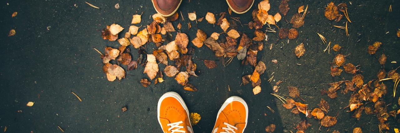 The Challenge of Social Anxiety for a Person on the Autism Spectrum close-up of two people's shoes as they stand in front of one another, with fall leaves at their feet