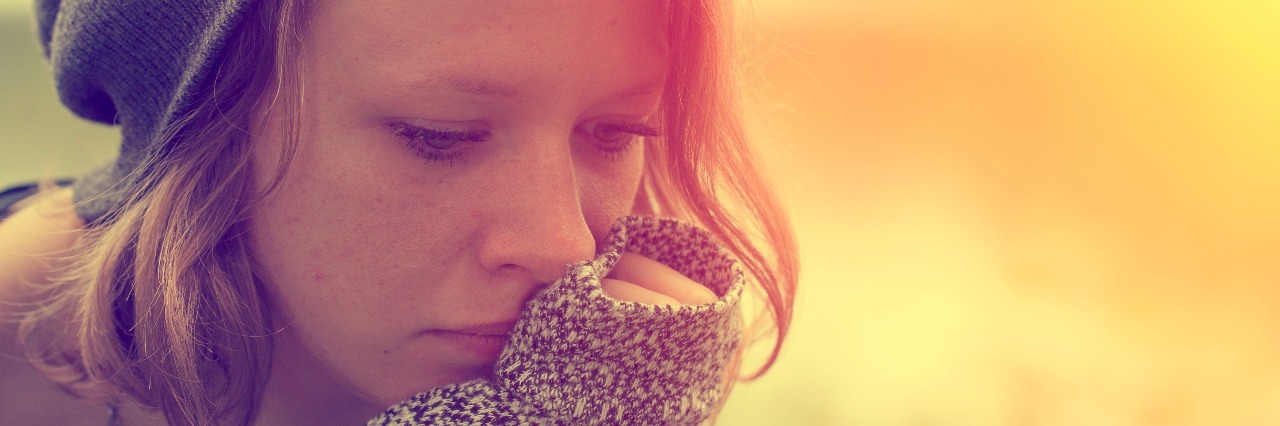 When People Tell Me I'm Too Young to Have Hypothyroidism woman with chin on hand looking sad