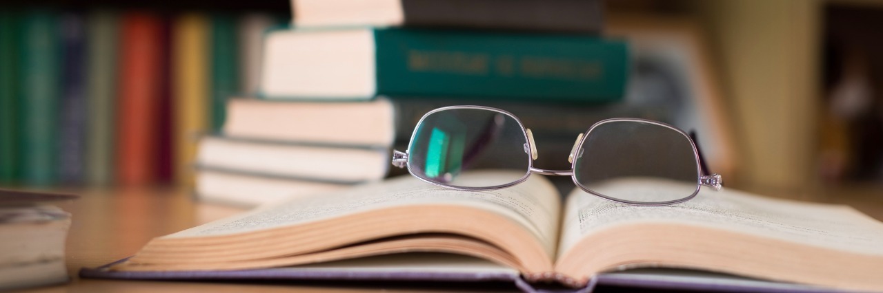 To the Teachers Who Doubted Me Because of My Illness Opened Book and a Stack of Books