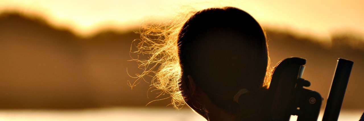 I See You Looking at My Child With a Disability: A Mom's Response Teenage girl with cerebral palsy sits in a wheel chair watching the sunset by a river.