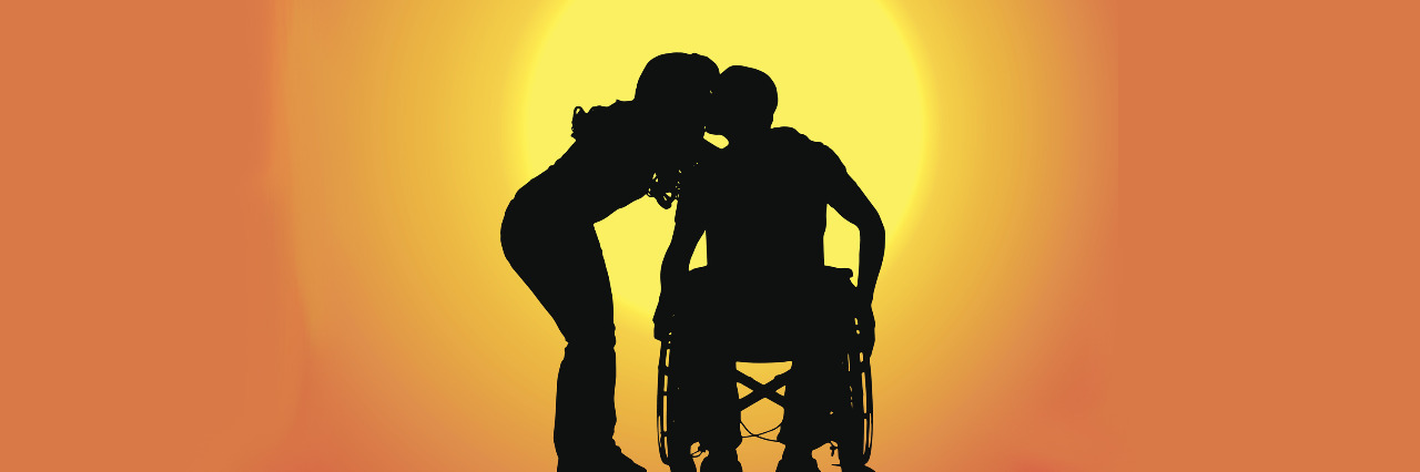 Silhouette of a male and female couple at sunset. The man uses a wheelchair.