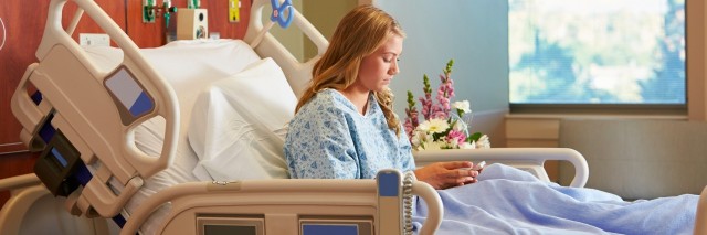 Teenage Female Patient In Hospital Bed Using Cellphone