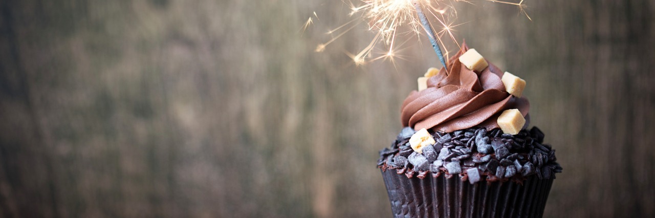 My Illness Doesn't Take a Holiday Chocolate cupcake with a sparkler