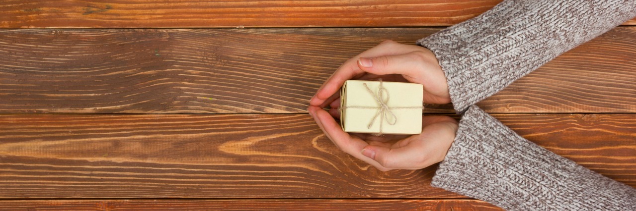 What POTS Took From Me and Gave Me In Return Present, gift. Close up of female hands holding small gift.