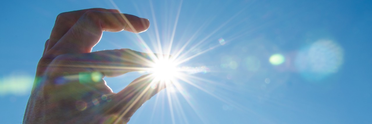 Starting a New Year With Anxiety A hand stretched out, so it looks like it's holding the sun