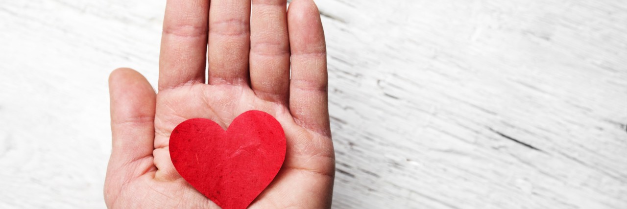 What to Tell Yourself When Bad Body Thoughts Are Triggered Heart in human hand. White wood background