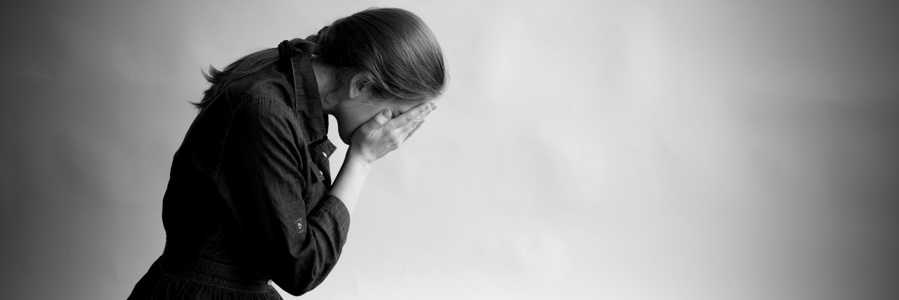 What Complicated Grief Is Like grieving woman on her knees with her face in her hands