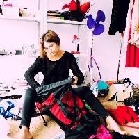 woman is packing backpack in a messy room
