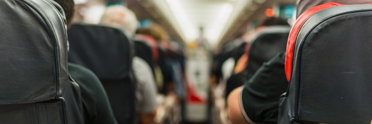 Flight Attendant Helps Boy With Sound Sensitivities While Dog Barks airplane aisle