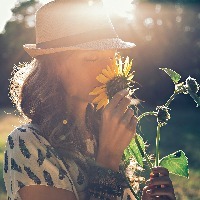 Girl smells sunflower in nature