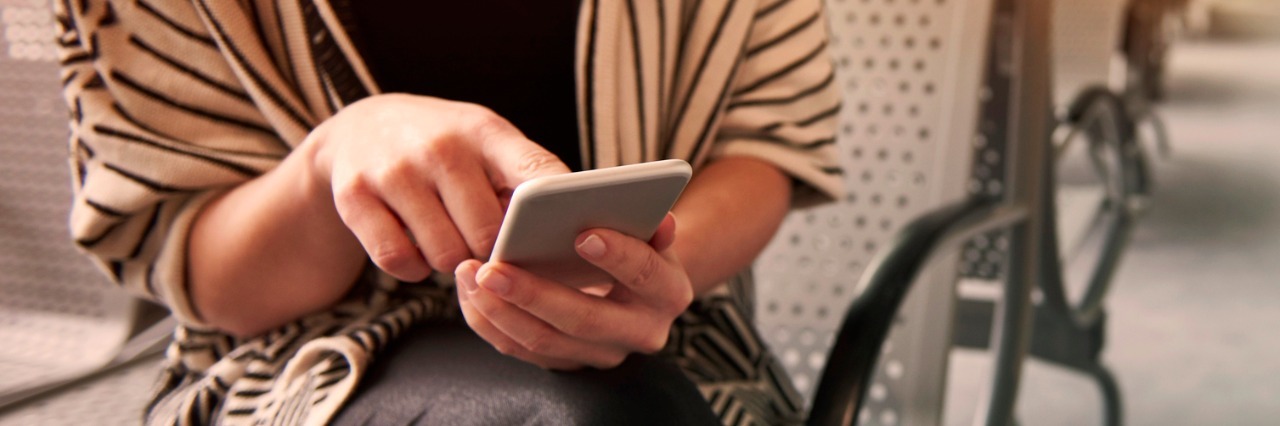 Online Dating Profiles and Letting Others Know I'm Autistic Woman sitting in chair, looking at cell phone