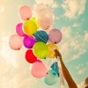 Girl hand holding colorful balloons. happy birthday party. vintage filter effect