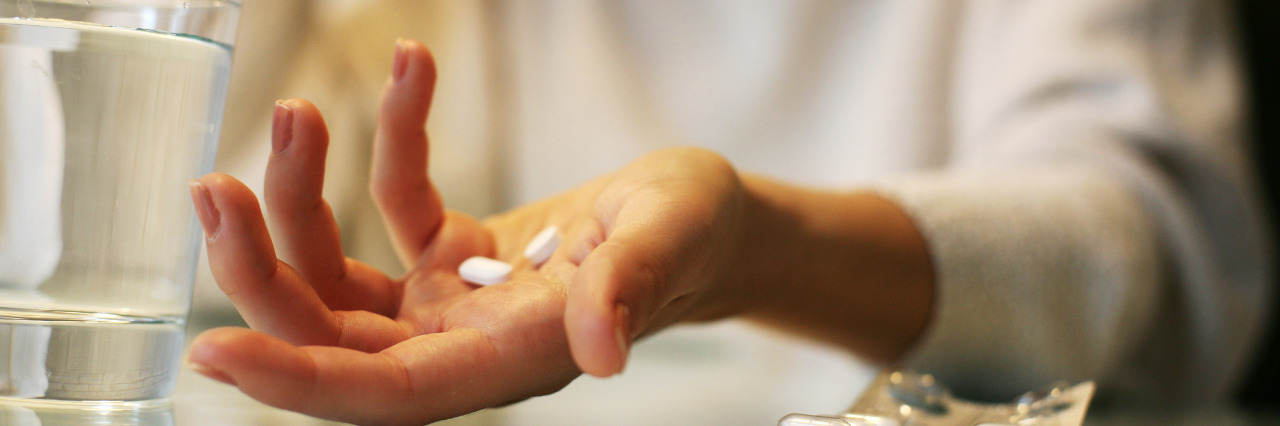 Pills in woman's hands.